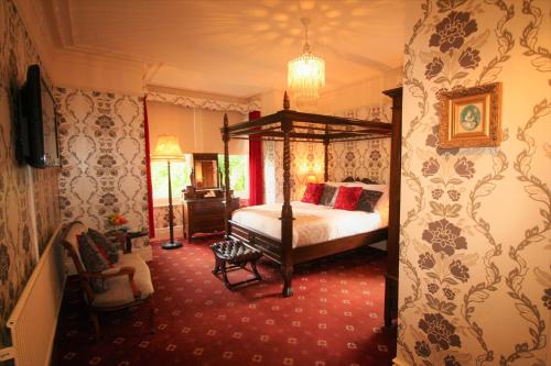 a bedroom with a canopy bed and red carpet at Kingscroft in Buxton