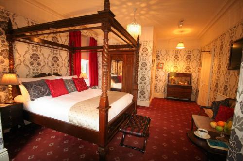 a bedroom with a canopy bed and a fireplace at Kingscroft in Buxton