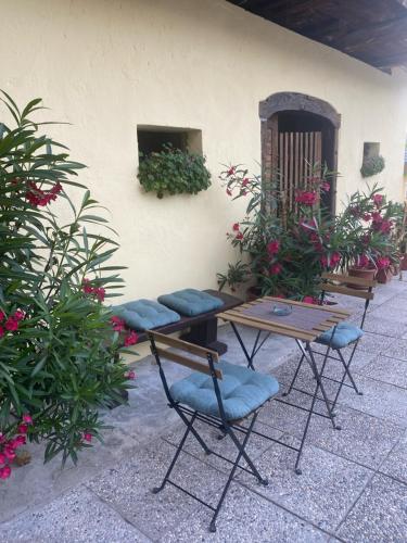 a patio with a table and chairs and flowers at Frida's Old House in Bled