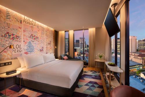 a hotel room with a bed and a large window at Hotel Indigo Adelaide Markets by IHG in Adelaide