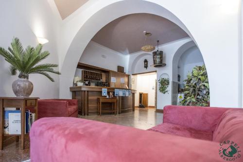 een woonkamer met een roze bank en een tafel bij Albergo Cappello e Cadore in Belluno