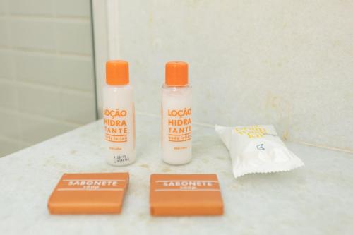 two bottles of sunscreen sitting on top of a counter at Golden Tulip Macaé in Macaé