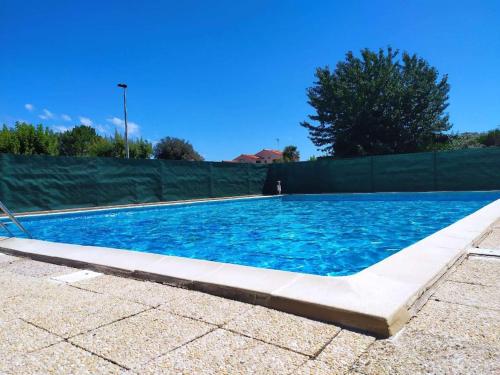 une piscine d'eau bleue et une clôture dans l'établissement Charmante maison de vacances proche mer commerces avec Piscine et wifi gratuit, à Vaux-sur-Mer