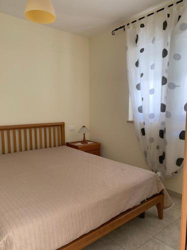 sypialnia z łóżkiem i zasłoną w obiekcie Appartamento in Villa a Policoro w mieście Policoro