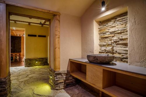 a bathroom with a stone wall and a bowl on a counter at Spa Hotel Anglický Dvůr in Karlovy Vary