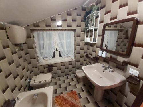 a bathroom with a sink and a toilet and a mirror at Villa l'Amante in Fondi