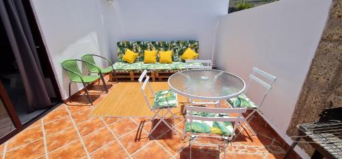 a living room with a couch and a table and chairs at Sunny Island Retreat in Tejina de Isora in Guía de Isora