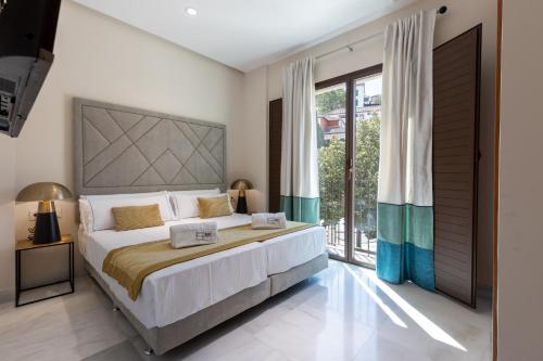 מיטה או מיטות בחדר ב-BiBo Suites Real Chancilleria