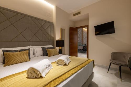 a bedroom with a large bed with towels on it at BiBo Suites Real Chancilleria in Granada