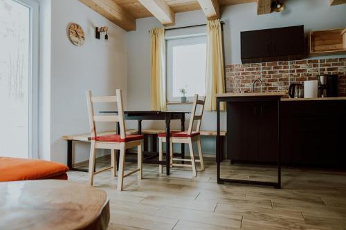 cocina y comedor con mesa y sillas en Domki Ciszy Mi Daj, en Wisła
