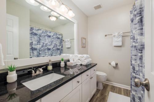 ein Badezimmer mit einem Waschbecken, einem WC und einem Spiegel in der Unterkunft Cute Condo in Rock Hill-49 in Rock Hill