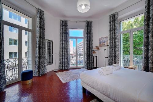une chambre avec un grand lit et de grandes fenêtres dans l'établissement IMMOGROOM - Fully equipped -AC- near Palais des Festivals, à Cannes