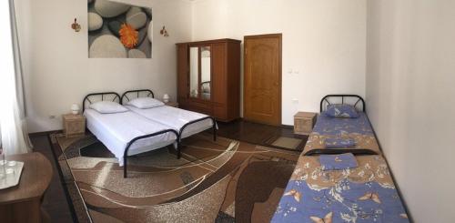 a room with two beds and a table in it at Gelena Гостьовий двір in Uzhhorod