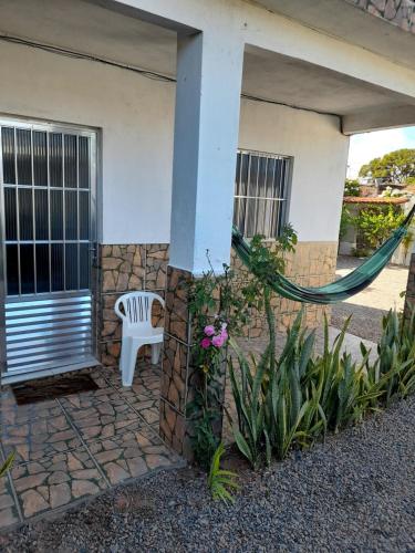 a white chair sitting outside of a house at Ap01-A 50 Metros da Praia Flats Mobiliados para 4 Pessoas in Paulista