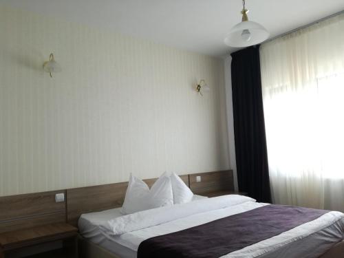 una camera da letto con un letto con lenzuola bianche e una finestra di Sport Avalanche a Ranca