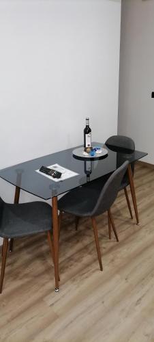 a black table with two chairs and a bottle of wine at O Salgueiro in Melo