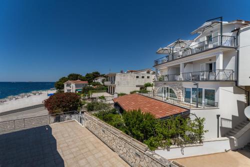 a view of the beach from the balcony of a building at Residence Bepi Malugio in Primošten