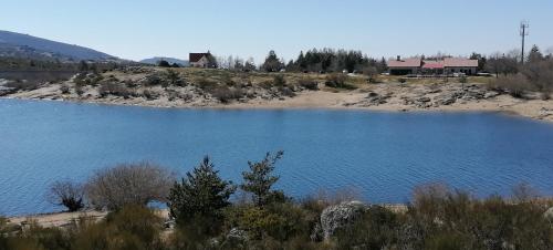 a large blue lake with a house in the background at O Salgueiro in Melo