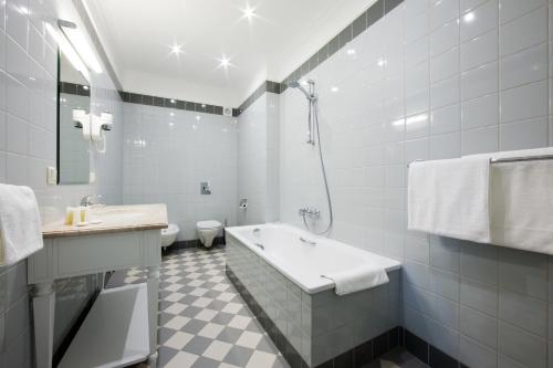 a bathroom with a tub and a toilet and a sink at Skrunda Manor in Skrunda