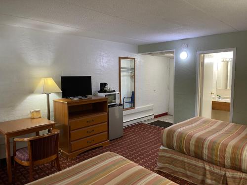 a hotel room with two beds and a desk and a room at The Autumn Inn in Bennington