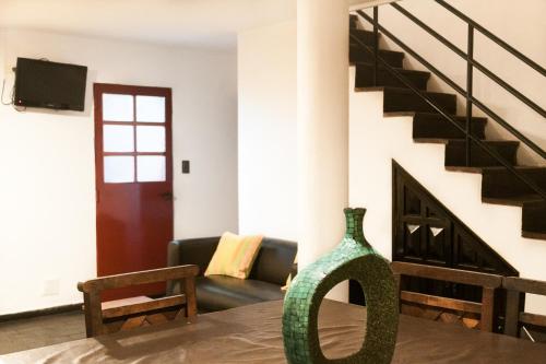 un jarrón verde sentado en una mesa en una sala de estar en Posada Alpenrose Neu, en Villa Carlos Paz