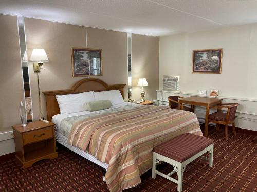 um quarto de hotel com uma cama e uma secretária em The Autumn Inn em Bennington