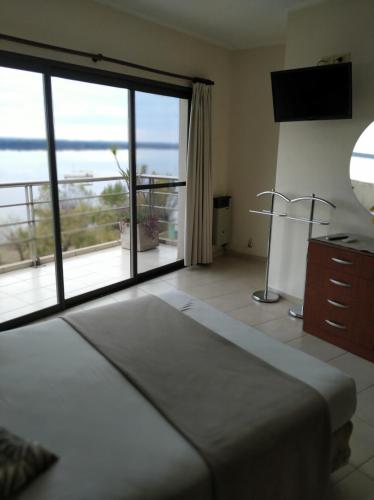 a bedroom with a bed and a large sliding glass door at NorthBeach ::: Dpto. 7 in Colón
