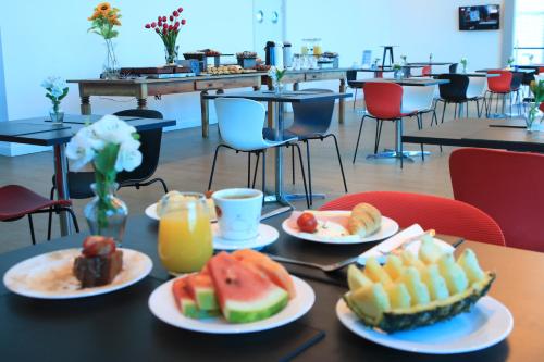 a table topped with plates of food and drinks at Transamerica Executive Taboao Morumbi in Taboão da Serra
