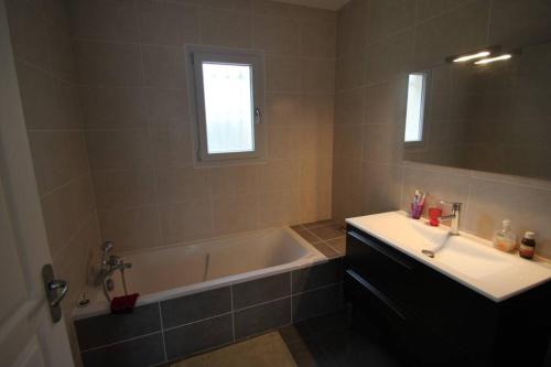 La salle de bains est pourvue d'une baignoire, d'un lavabo et d'un miroir. dans l'établissement Amour Périgord, à Montignac