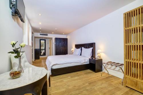 a bedroom with a bed and a table and a television at Dolphin Suites in Veli Lošinj