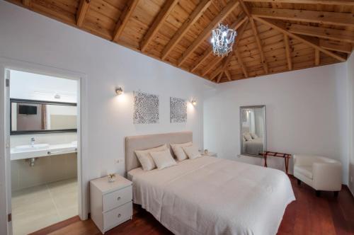a bedroom with a white bed and a chandelier at Villas Taburiente in Los Llanos de Aridane