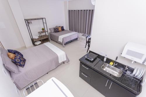 um quarto de hotel com duas camas e um lavatório em Hotel Amsterdam Suítes em Holambra