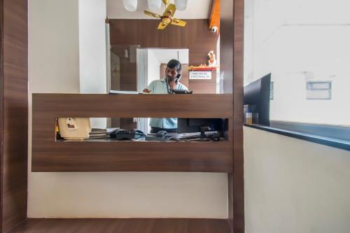 a reflection of a man in a mirror at Aasra Lodge in Ratnagiri