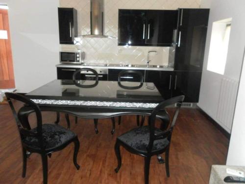 a kitchen with a table with two chairs and a stove at Montanhas do Douro in Paredes da Beira
