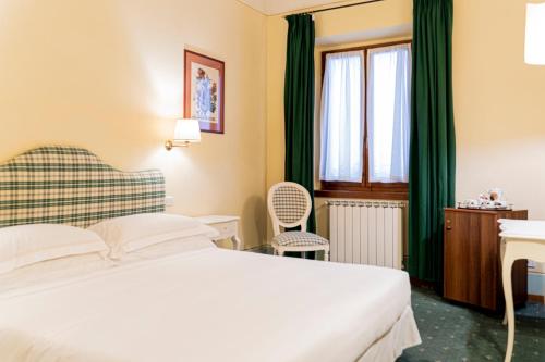 a hotel room with a bed and a window at Casa Uffizi XIII Century Tower House Boutique Hotel in Florence