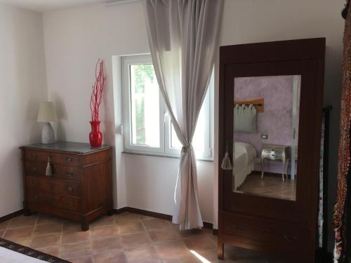 Pokój z lustrem, komodą i oknem w obiekcie A casa di Andre’ w mieście Vara Superiore