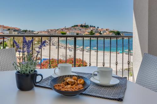 a table with a bowl of food and a view of the beach at Residence Bepi Malugio in Primošten