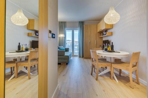 a dining room and living room with a table and chairs at Residence Bepi Malugio in Primošten