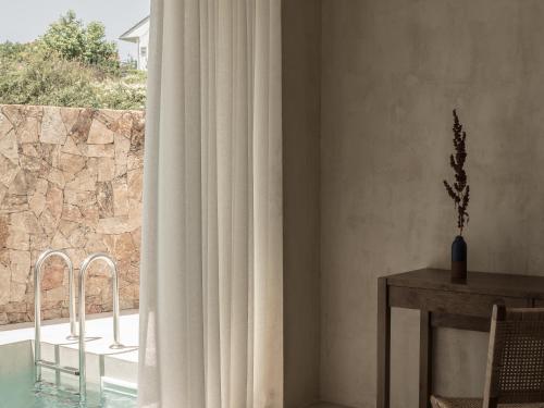a dining room with a table and a window at Seven Rocks in Paliouri