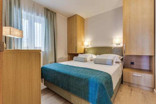 a hotel room with a bed and a window at Residence Bepi Malugio in Primošten