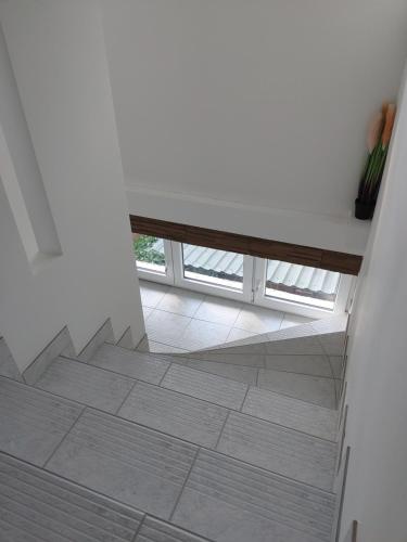 a stairway with a bench in a white room at Fiesta Apartman in Miskolctapolca