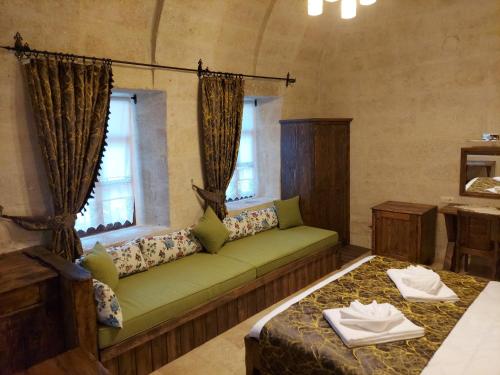 a living room with a couch and two windows at ARMEsos Cave Hotel in Urgup