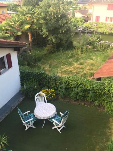 a patio with a table and two chairs on the grass at Al Centrale di Piazzogna in Gambarogno