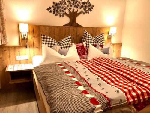 a bedroom with a large bed with a tree on the wall at Veronika Appartements in Sankt Jakob in Defereggen