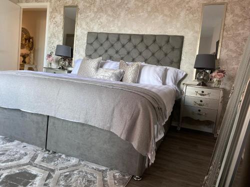 a bedroom with a large bed and two night stands with lamps at Hideaway Bay in Swansea