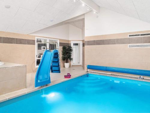 a swimming pool with a blue slide in a room at 18 person holiday home in Hasselberg in Kappeln