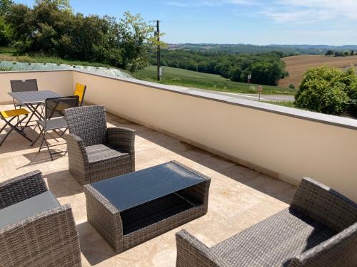 a patio with chairs and a table on a balcony at Jolie Appartement à la campagne in Hautesvignes