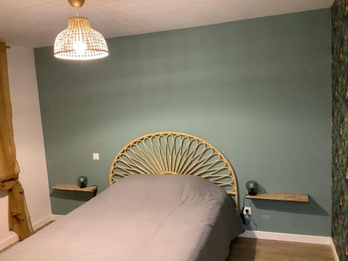 a bed in a room with a green wall at Jolie Appartement à la campagne in Hautesvignes