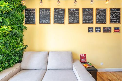 a couch in a room with a wall with signs at We Love F Tourists in Lisbon