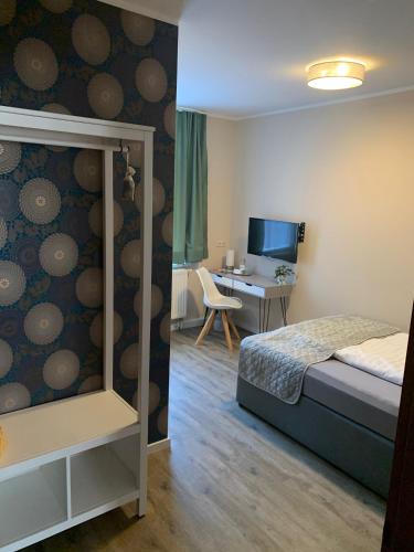 a bedroom with a bed and a desk with a computer at Pension Triebischtal in Meißen